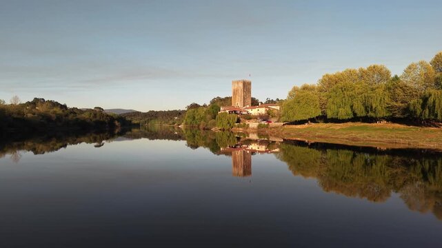 Lapela tower a medieval castle reflecting in the calm waters of minho river