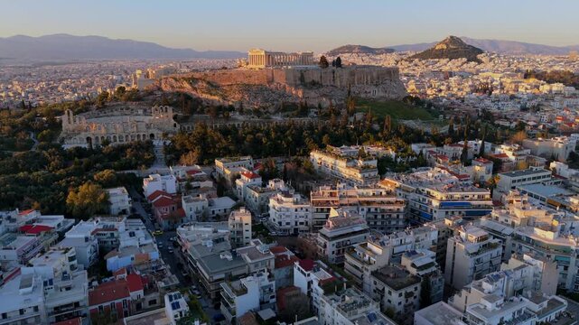 Aerial  Video of Athens Cityscape at Sunset featuring Acropolis, Parthenon, and Odeon of Herodes Atticus, and Lycabettus Hill. 
