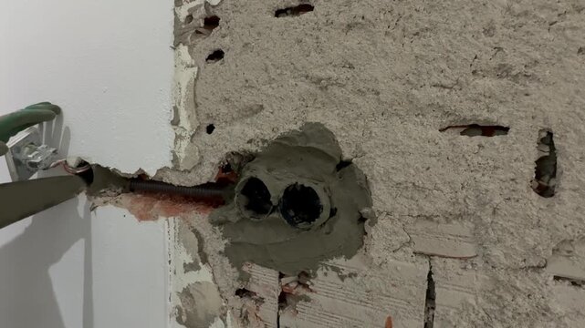 Wall construction repair. socket repair, large plpnom spatula and cement. Electrical wires wall. Wall socket hole. repair, replacement of sockets, electrical wiring. High quality 4k footage