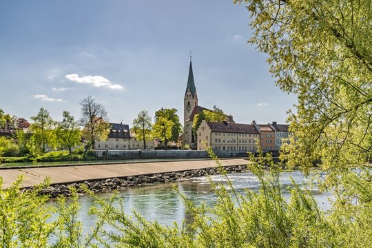 Iller river with A&Uuml;W hydroelectric power plant weir and the historic St Mang church in Kempten during a sunny spring day
