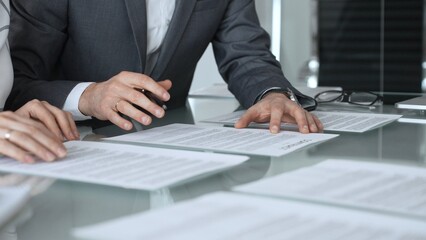 Business professionals discussing contract terms, lawyer explaining clauses, clients making...