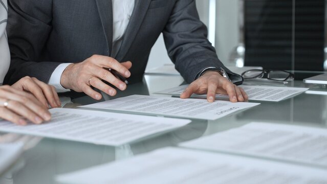 Business professionals discussing contract terms, lawyer explaining clauses, clients making agreements during a corporate meeting. Business people concept