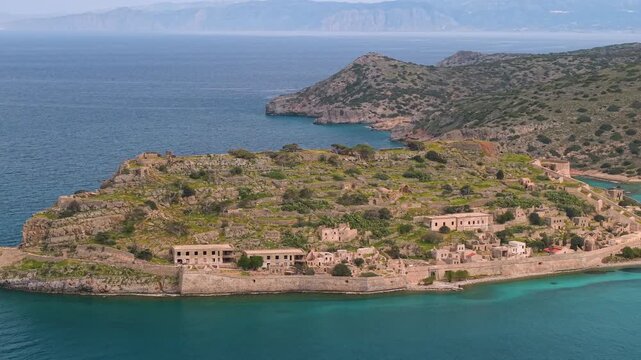 Greece Crete Spinalonga Island 4K Drone Video of Venetian Fortress and Former Leper Colony Ruins with Turquoise Sea Water and Tourist Boat in Plaka Bay Travel Aerial