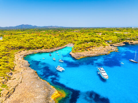 Aerial view of Cala Mondrago bay,  Balearic islands, Mallorca, Spain. Scenic coastline landscape with boats and yachts in summer. Mediterranean nature and vacation destination from drone.