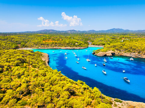 Aerial view of Cala Mondrago bay,  Balearic islands, Mallorca, Spain. Scenic coastline landscape with boats and yachts in summer. Mediterranean nature and vacation destination from drone.