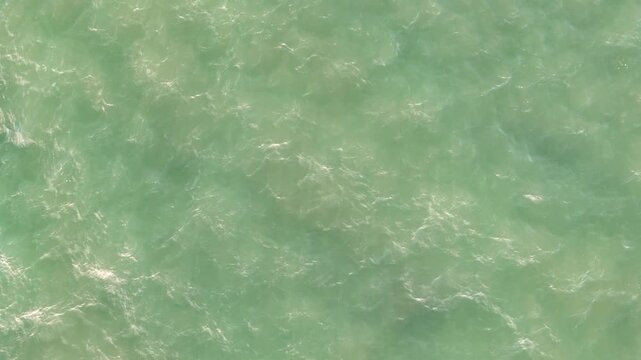 Green ocean sea water surface with small waves aerial drone view