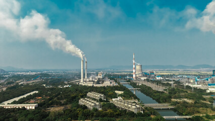 Obraz premium Thermal plant across a water channel with a green spread 