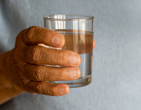 A person holding a glass of water
