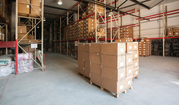 Warehouse interior storing stacked boxes on pallets in industrial racks