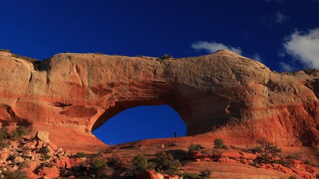Large natural sandstone arch in red rock desert.