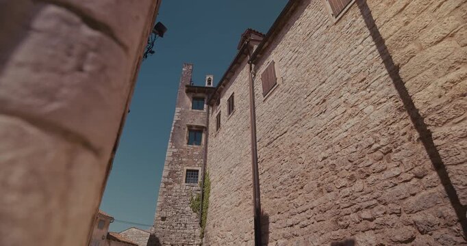 Narrow street with stone tower in Bale