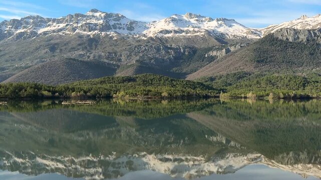 Beautiful morning light on mountain peaks and peaceful lake reflection