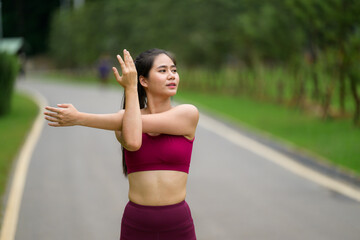 Fototapeta premium Young Asian woman stretching arm warming up for exercise