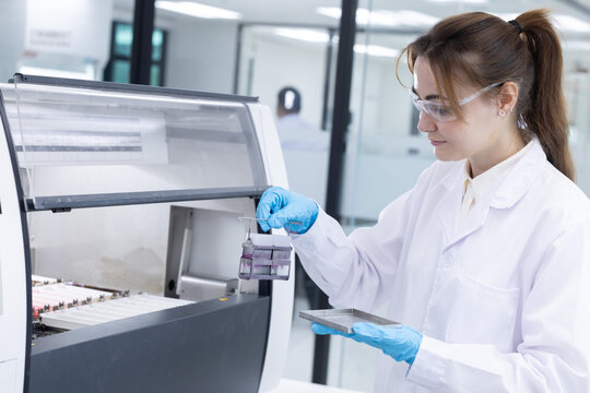 A laboratory pathologist using automatic multi slide stainer machine in a laboratory