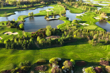 Naklejka premium Panoramic golf course view with lakes and green forest