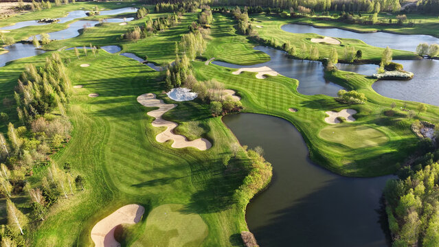 Beautiful summer golf course with forest and water view