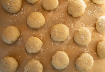 Fototapeta premium Overhead view of cardamom bun dough on a baking sheet, sprinkled with flour