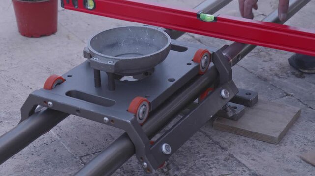Crew Member Leveling Camera Slider with Bubble Level on Film Set