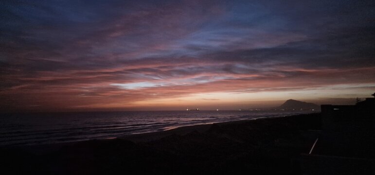 Sanfte Wellen am Strand bei einem lila Sonnenuntergang am Mittelmeer