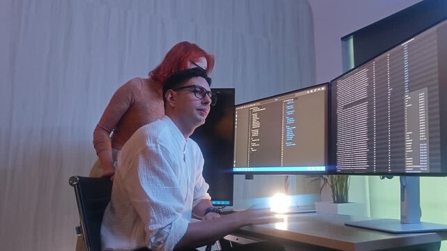 Programmers working at night analyzing code on monitors in a modern office. Software developers collaborating on debugging cybersecurity and data programming projects. Ai coding Software technician.
