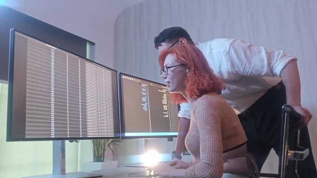 Programmers working at night analyzing code on monitors in a modern office. Software developers collaborating on debugging cybersecurity and data programming projects. Ai coding Software technician.
