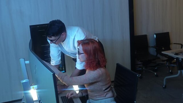 Programmers working at night analyzing code on monitors in a modern office. Software developers collaborating on debugging cybersecurity and data programming projects. Ai coding Software technician.