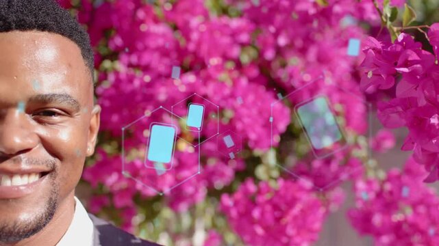 Man left reacting, smiling to cyan hex icons drifting over face to bougainvillea for promo portrait