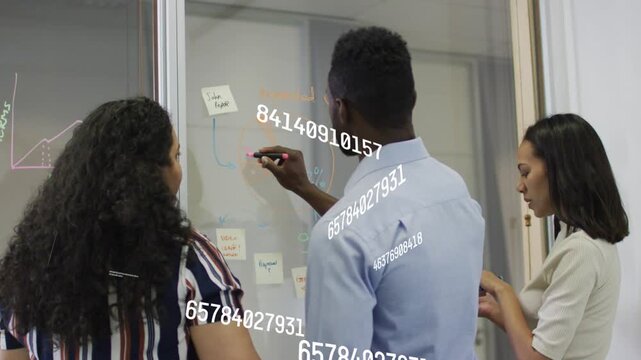 Man picking marker, drawing on glass, women moving sticky notes, data overlays aiding project plan