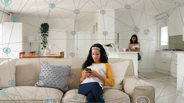 Female mother and teen daughter sitting and using phone with papers in living room, network overlay