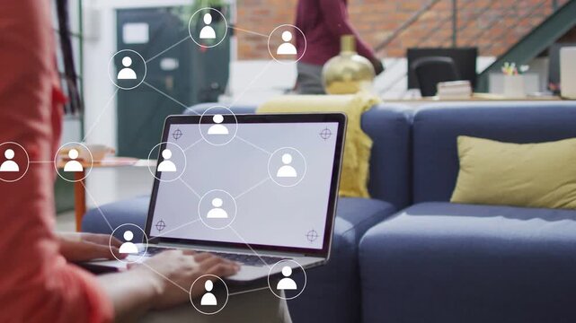 Woman typing laptop in tech loft sparking user nodes growing across laptop and sofa forming network