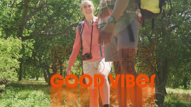 Hikers balancing on fallen log causing orange GOOD VIBES graphic appearing showing travel vibe