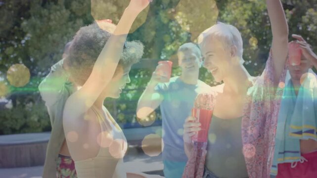 Two friends sharing glance, dancing on pool deck while group toasting, bokeh over red cups event
