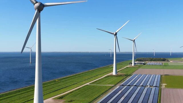 Aerial drone view of solar panels and wind turbines in a renewable energy farm. Sustainable green power station for clean electricity production and environmental technology infrastructure.