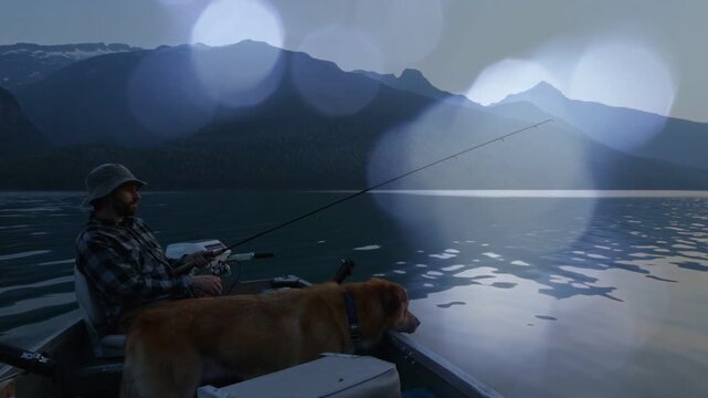 Male angler casting and watching fishing line in mt lake dog peering, bokeh overlaying seeking bite
