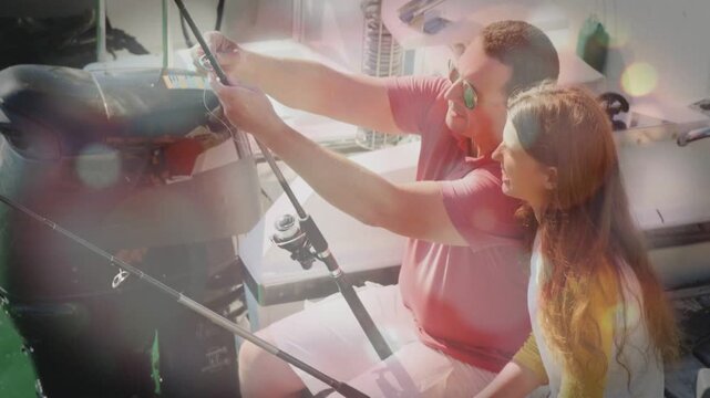 After looking at motor, adult male leaning, adjusting fishing rod for cast, teen female watching