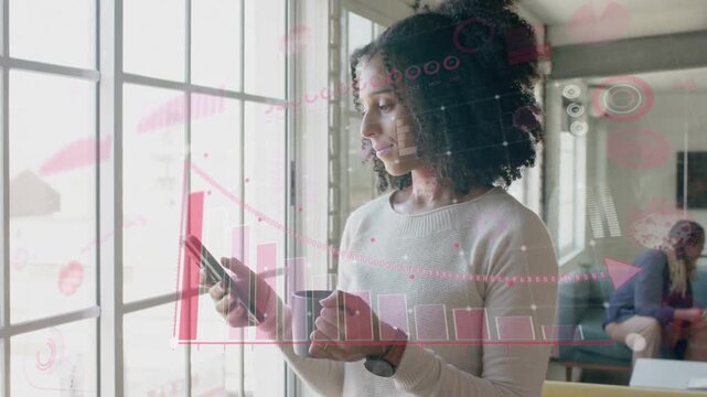 Woman standing by window tapping smartphone and building pink data charts for business analysis