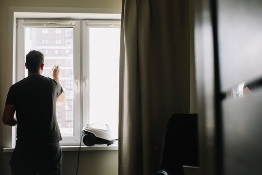 Man washing and cleaning window at home. Housework and housekeeping, home hygiene
