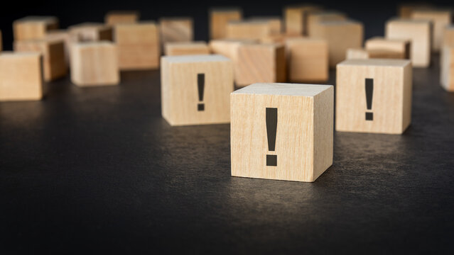 Wooden blocks with exclamation marks among scattered blank cubes.
