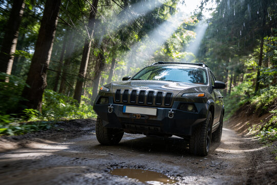 Jeep Cherokee Trailhawk on forest road. Trip through the forest August 2025. Dramatic view.