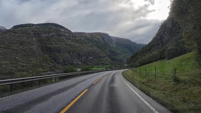 Point of view driving a recreational vehicle through a stunning mountain valley in Scandinavia