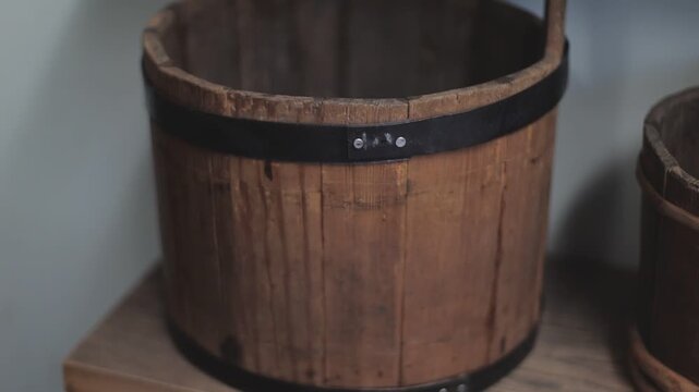 A simple wooden bucket sitting on a flat surface