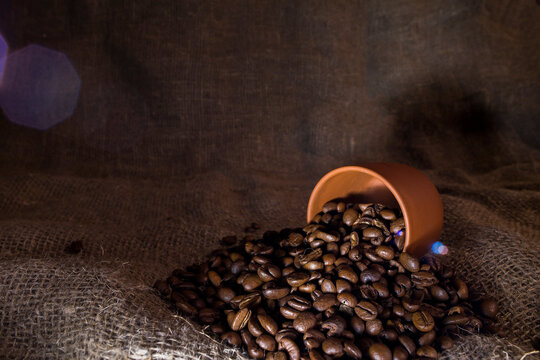 Coffee beans poured into a coffee cup.