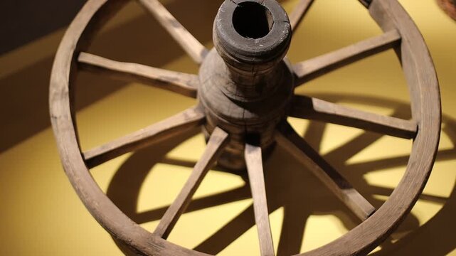A wooden wagon wheel with a single wooden spoke, ready for use or display
