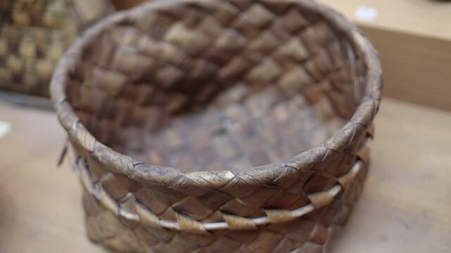 A close-up shot of a basket placed on a table, possibly holding fruit or other items