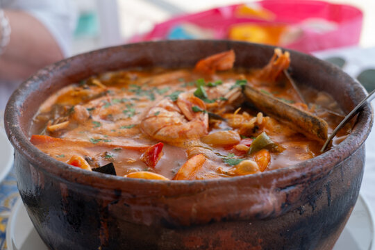 Traditional Portuguese seafood rice served in a rustic clay pot with prawns