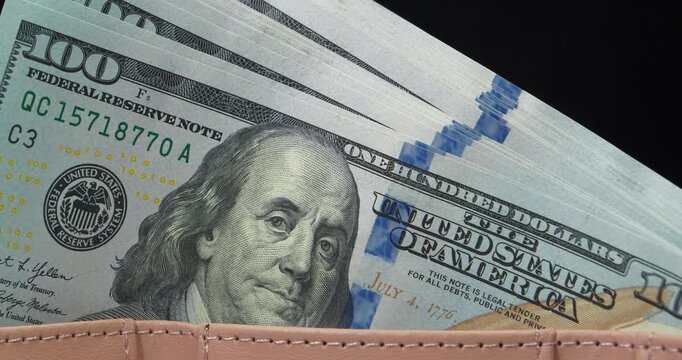 Wallet filled with a stack of new hundred-dollar bills. Cash. New 100 dollar bills, USD. New hundred dollar bills in a wallet