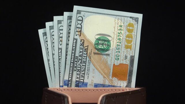 American dollars in wallet. Five new 100 dollar bills. 500 dollars in wallet. Cash. New hundred dollar bills in leather wallet
