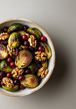 Delicious roasted sprouts mixed with tart red cranberries and crunchy walnut halves in a ceramic bowl, creating a festive holiday side dish, side, culinary, walnuts