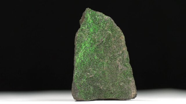 Uvarovite - calcium-chromium silicate mineral, an emerald-green variety of garnet. Small green crystals on the stone surface