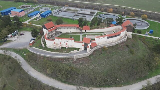 Aerial view of the restored Feldioara Marienburg medieval fortress in Brasov, Transylvania. Cinematic drone shot of the Teutonic Knights' castle with defensive walls and towers in Romania.